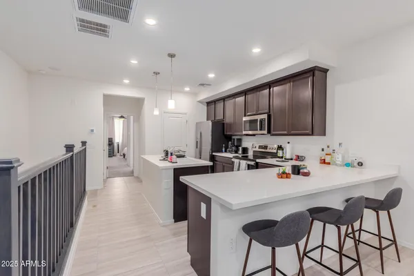 a kitchen with a sink a stove a refrigerator and chairs