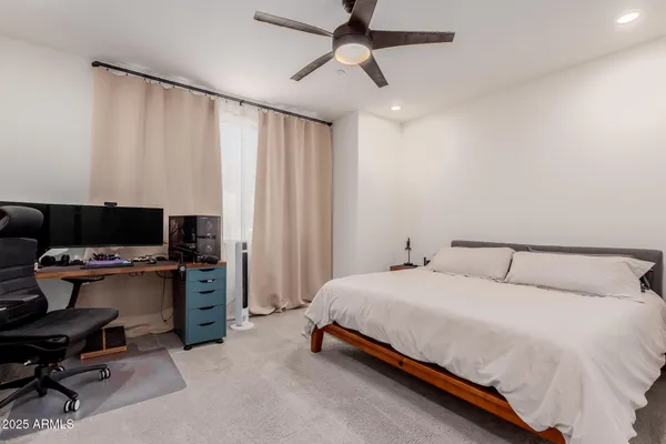 a bedroom with a bed and a computer on a desk
