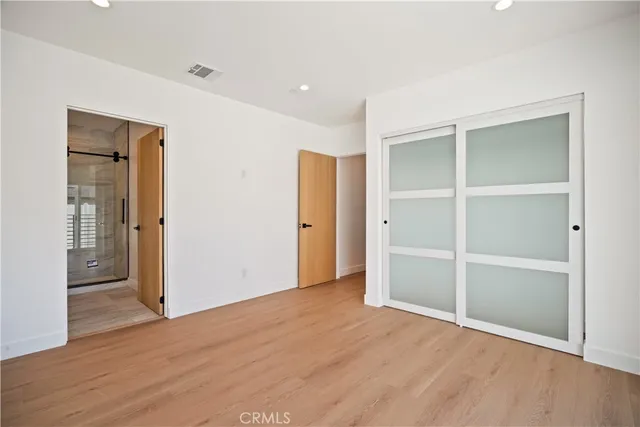 a large kitchen with stainless steel appliances granite countertop a stove a sink dishwasher and a refrigerator with wooden floor