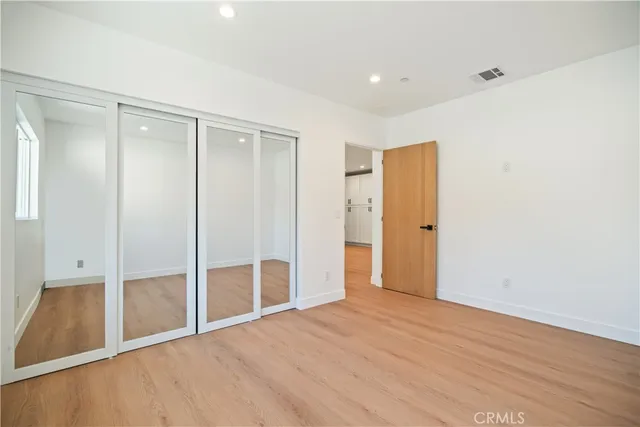 an empty room with wooden floor and a window