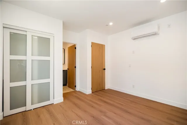 an empty room with wooden floor and natural light