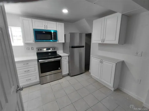 a kitchen with white cabinets and stainless steel appliances