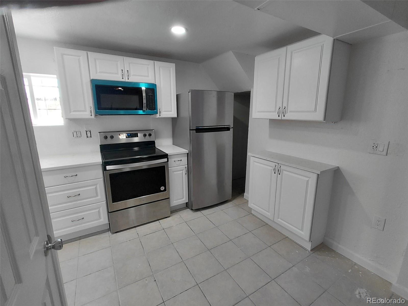 274 South Meade Street Denver, CO 80219 - Photo 2 of 14 a kitchen with white cabinets and stainless steel appliances