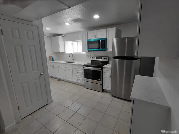 a kitchen with stainless steel appliances a refrigerator sink and microwave