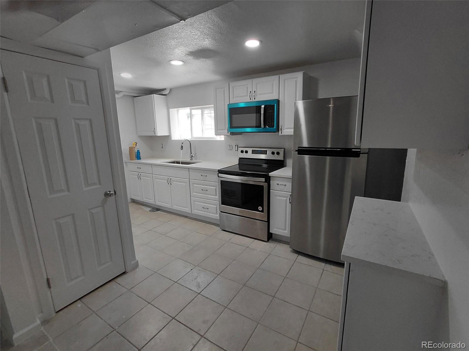 274 South Meade Street Denver, CO 80219 - Photo 3 of 14 a kitchen with stainless steel appliances a refrigerator sink and microwave