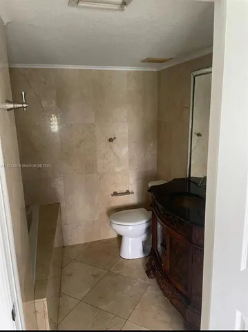 a bathroom with a granite countertop toilet a sink and a shower