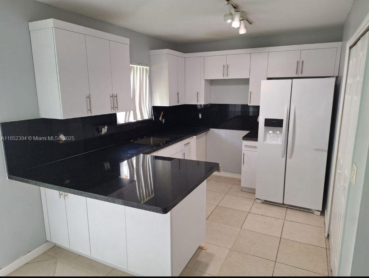 2701 Southeast 12th Road, Unit 106 Homestead, FL 33035 - Photo 8 of 21 a kitchen with granite countertop a refrigerator and a sink
