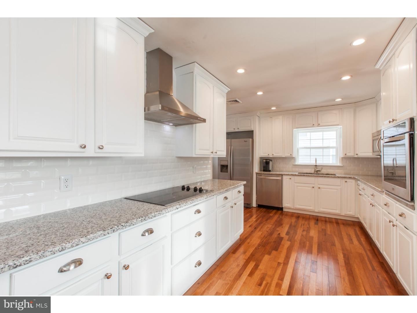 1238 Dill Road Havertown, PA 19083 - Photo 4 of 23 a large white kitchen with stainless steel appliances granite countertop a lot of counter space and wooden floors