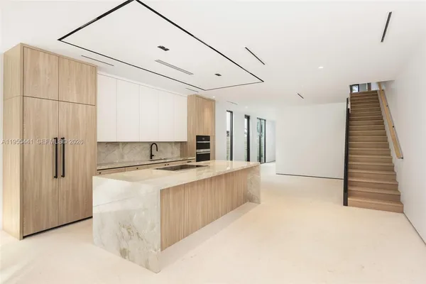a kitchen with kitchen island a stove a refrigerator and a sink