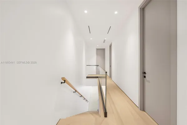 a view of a hallway with wooden floor and entryway