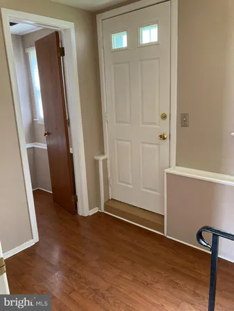 an empty room with wooden floor and entrance