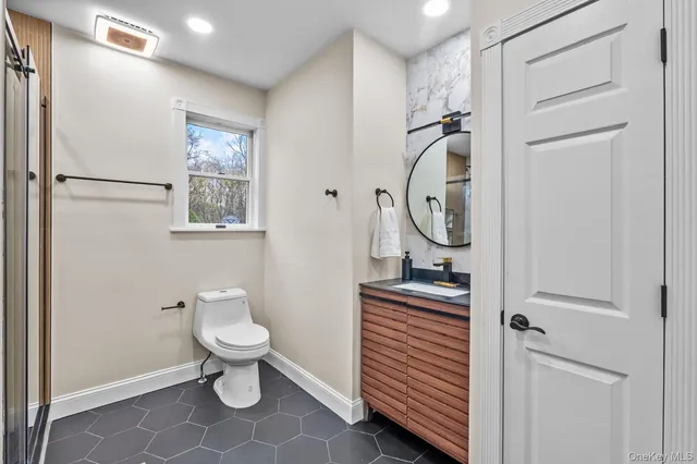 a bathroom with a toilet a sink and a mirror