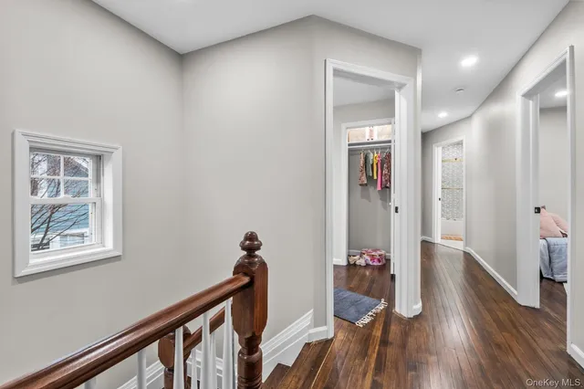 a view of a hallway with wooden floor and closet