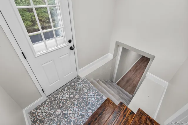 a view of staircase with white walls and a rug