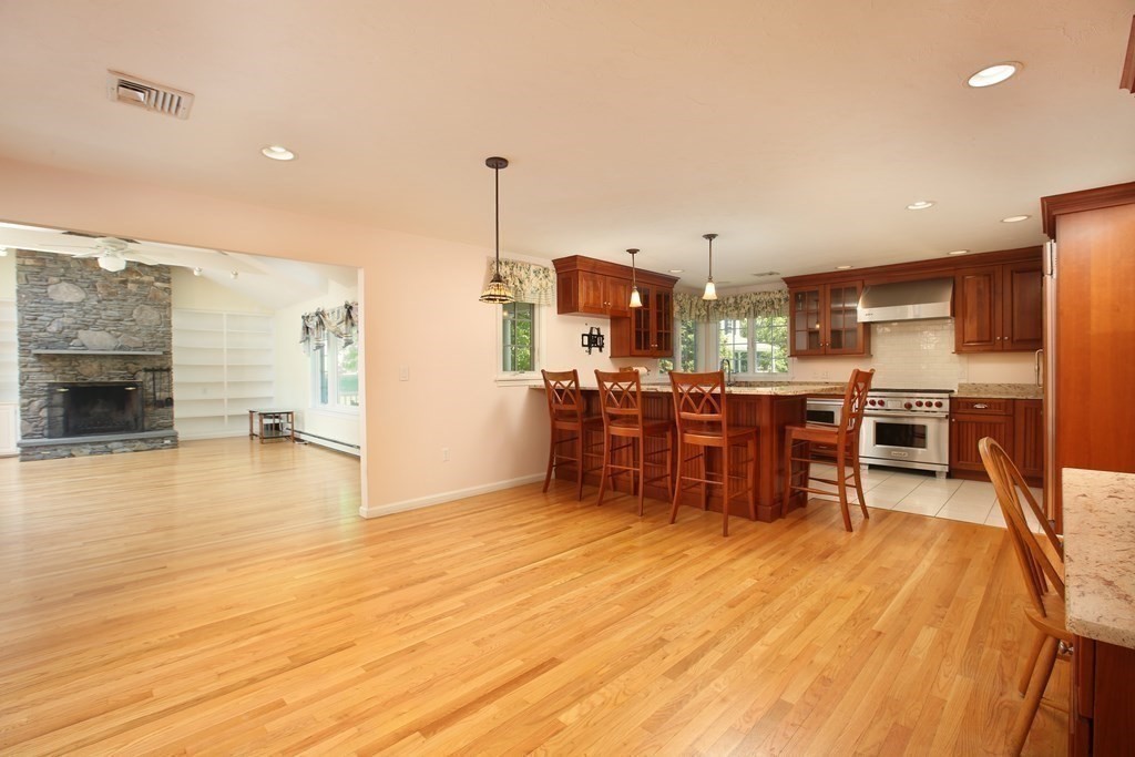 5 Charles Everett Way Hingham, MA 02043 - Photo 11 of 27 a kitchen with stainless steel appliances a dining table chairs and stove top oven