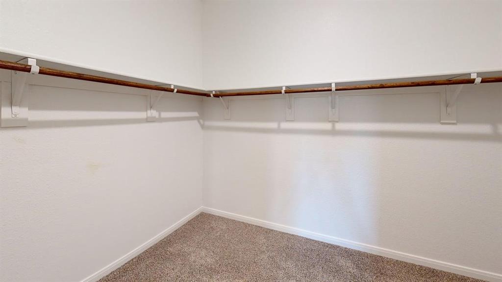 1306 Colonial Bluff Lane Princeton, TX 75407 - Photo 22 of 27 Spacious walk-in closet featuring white walls, baseboards, and neutral-toned carpeting