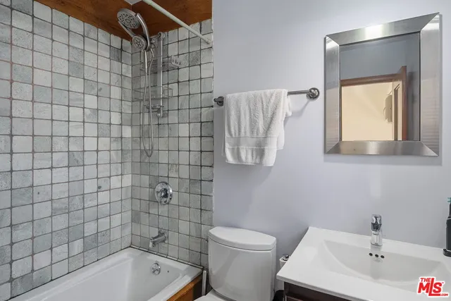 a bathroom with a bathtub shower sink vanity and toilet
