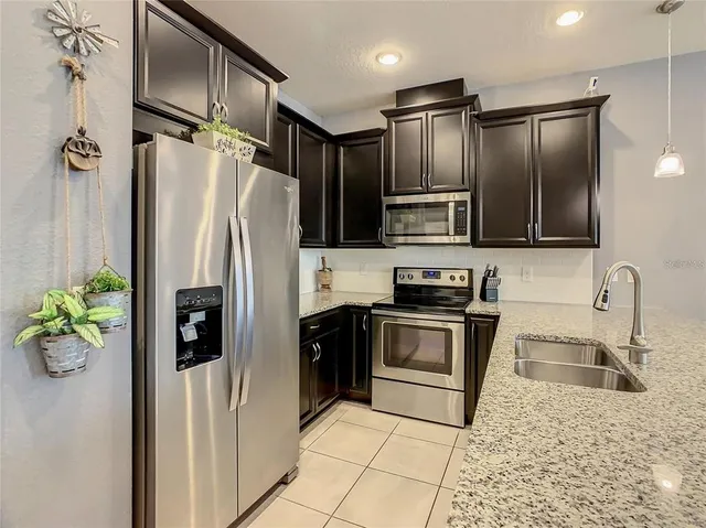 a kitchen with a sink a counter space cabinets and stainless steel appliances