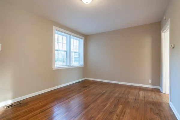 a view of a room with wooden floor and windows in a room