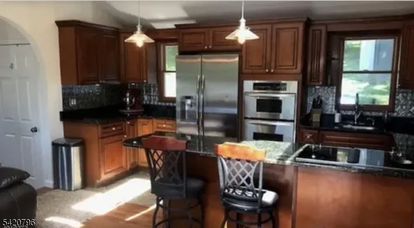 a kitchen with stainless steel appliances wooden floor dining table and chairs