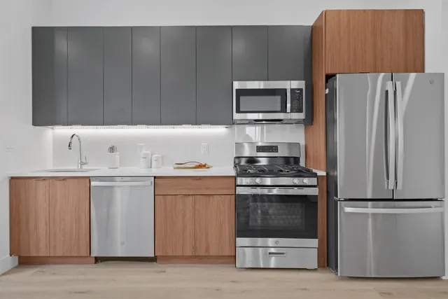a kitchen with stainless steel appliances a stove a microwave and a refrigerator