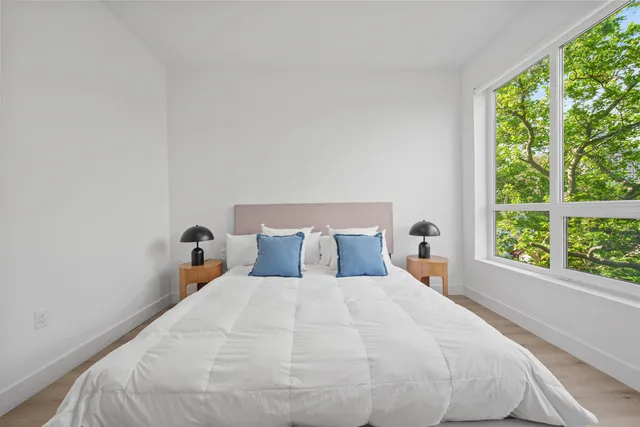 a large bed sitting in a bedroom next to a window