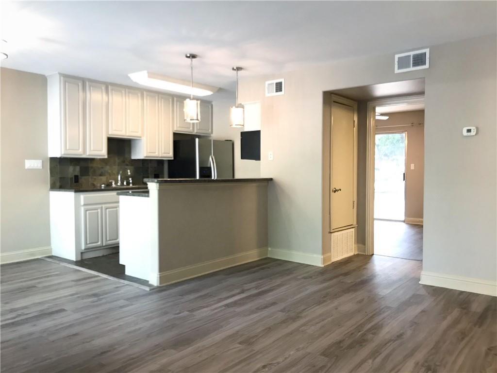 500 East Riverside Drive, Unit 154 Austin, TX 78704 - Photo 3 of 13 Kitchen featuring dark countertops, stainless steel fridge with ice dispenser, hanging light fixtures, dark wood-type flooring, and backsplash