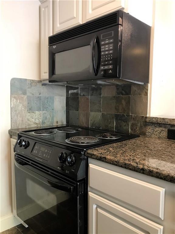500 East Riverside Drive, Unit 154 Austin, TX 78704 - Photo 5 of 13 Kitchen with black appliances, dark stone counters, and tasteful backsplash