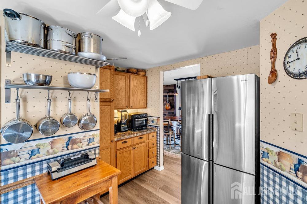 720 Voorhees Avenue Middlesex, NJ 08846 - Photo 11 of 28 a kitchen with stainless steel appliances a refrigerator a stove a sink and a dining table with wooden floor