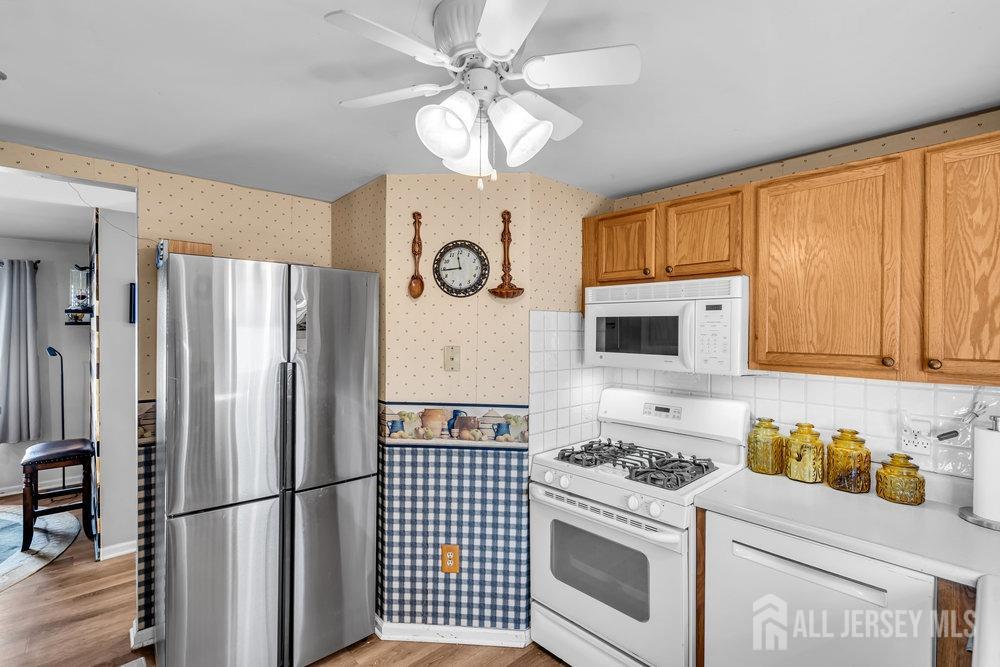 720 Voorhees Avenue Middlesex, NJ 08846 - Photo 12 of 28 a kitchen with stainless steel appliances granite countertop a stove a refrigerator and a refrigerator with wooden floors