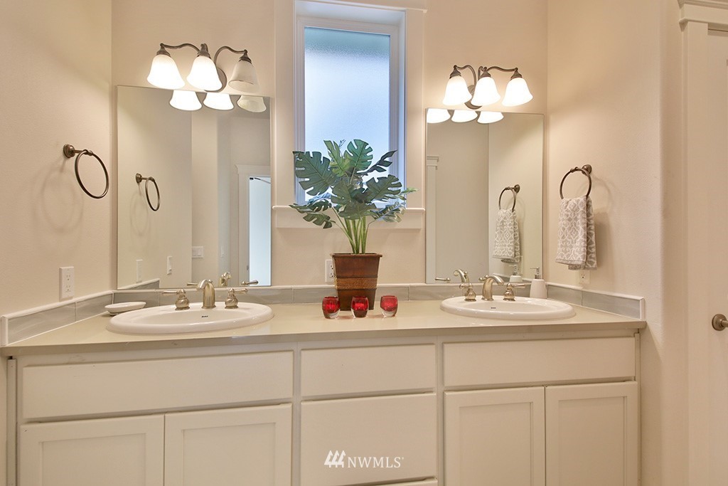 1822 East Watkins Road Freeland, WA 98249 - Photo 14 of 25 a bathroom with double vanity sinks a vanity a lamp and a mirror