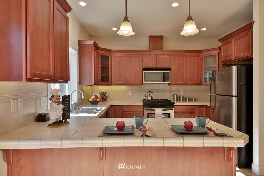 1822 East Watkins Road Freeland, WA 98249 - Photo 8 of 25 a kitchen with stainless steel appliances granite countertop a sink a stove and refrigerator