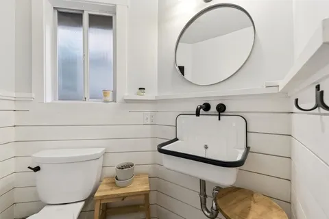 a bathroom with a sink mirror and toilet