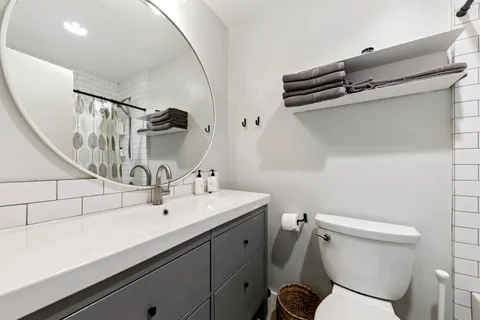 a bathroom with a sink a toilet and mirror