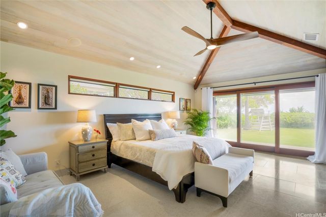 a bedroom with furniture and a large window