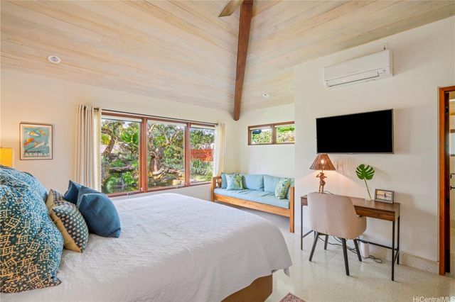 a bedroom with a bed tv and window