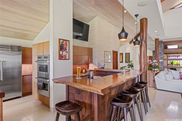 a kitchen with stainless steel appliances kitchen island granite countertop a table chairs in it and wooden floors
