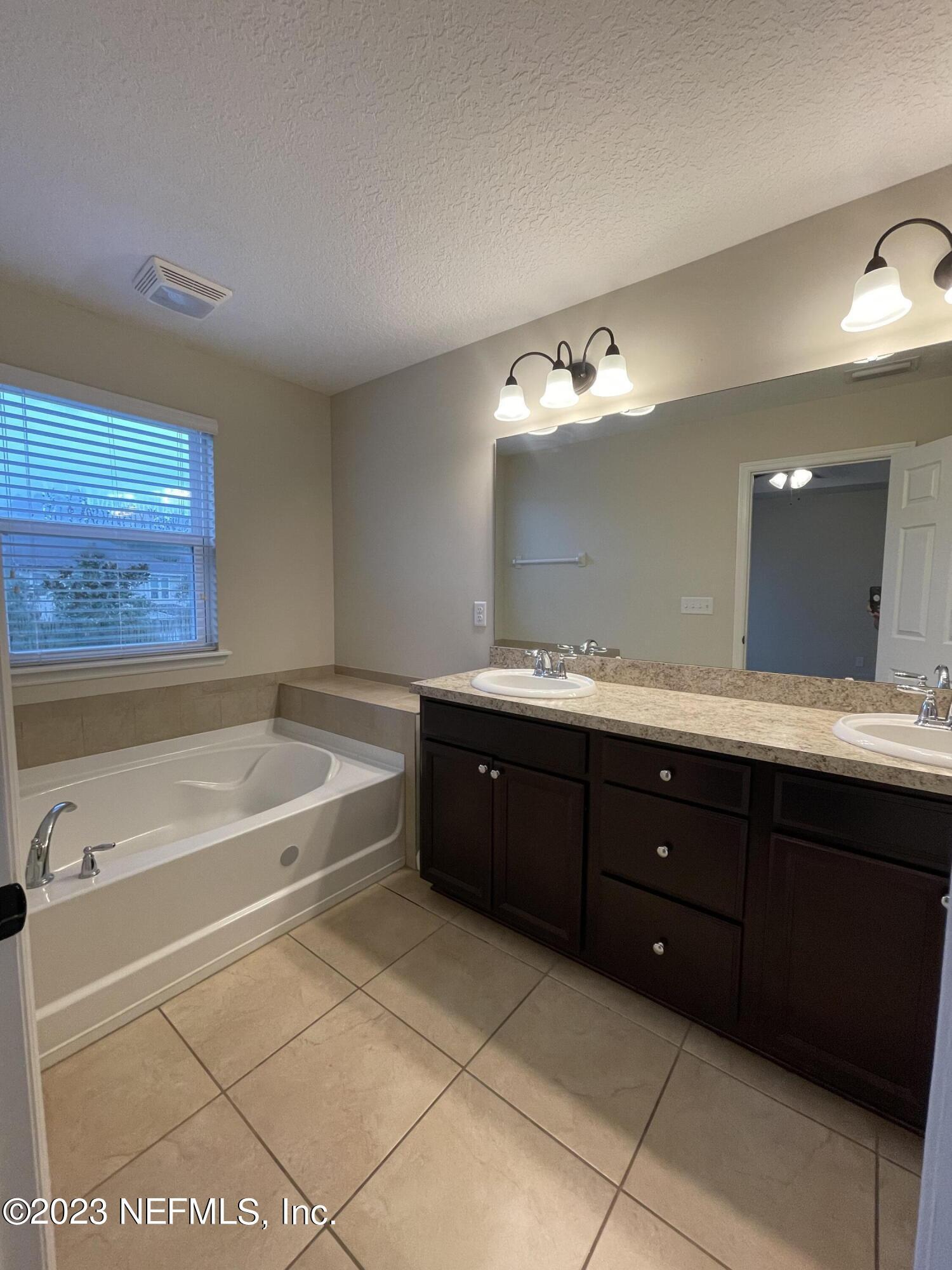 41 Nelson Lane St. Johns, FL 32259 - Photo 11 of 18 a spacious bathroom with a tub sink and mirror