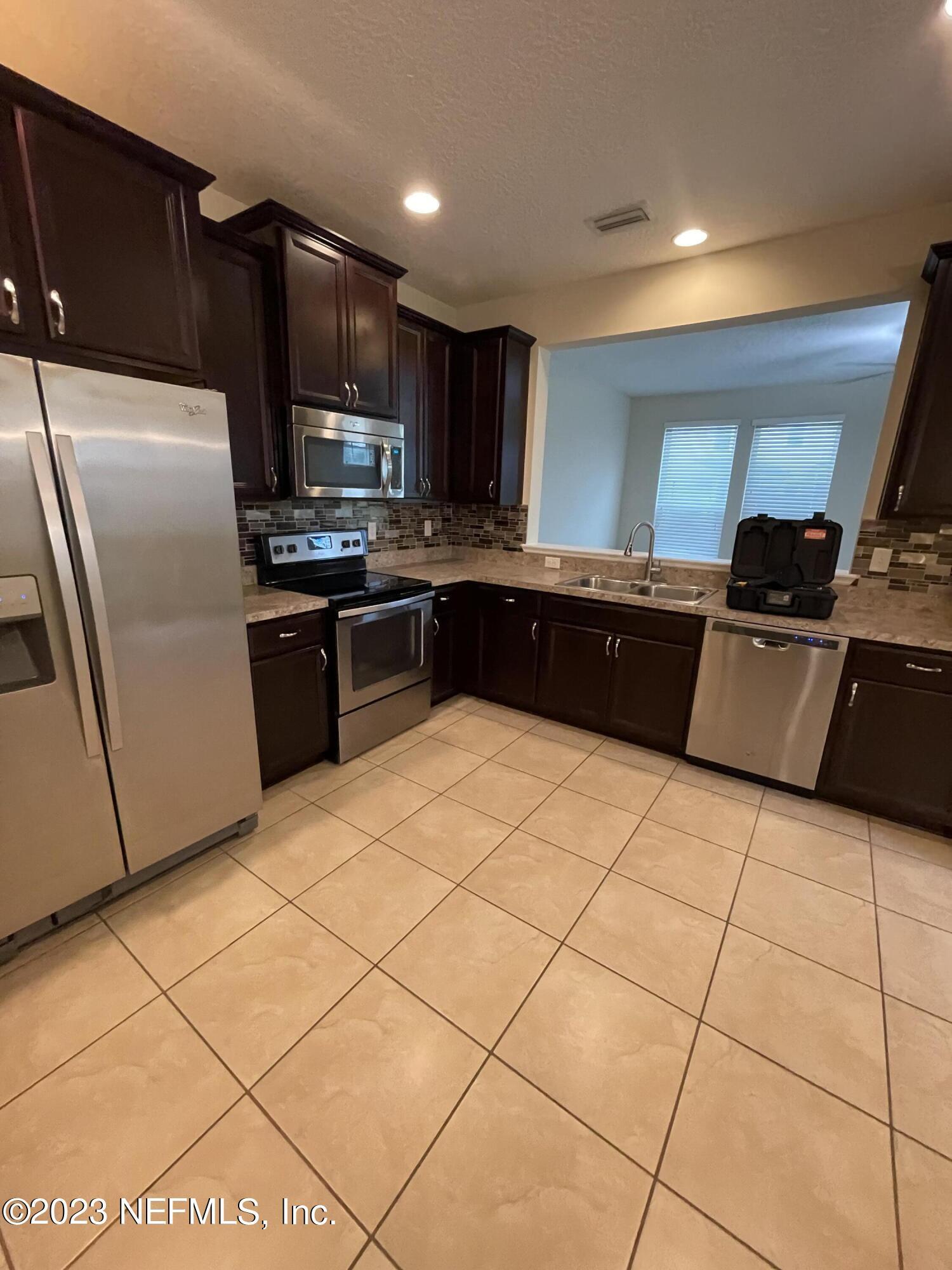 41 Nelson Lane St. Johns, FL 32259 - Photo 17 of 18 a kitchen with stainless steel appliances granite countertop a refrigerator a sink a stove a microwave and island