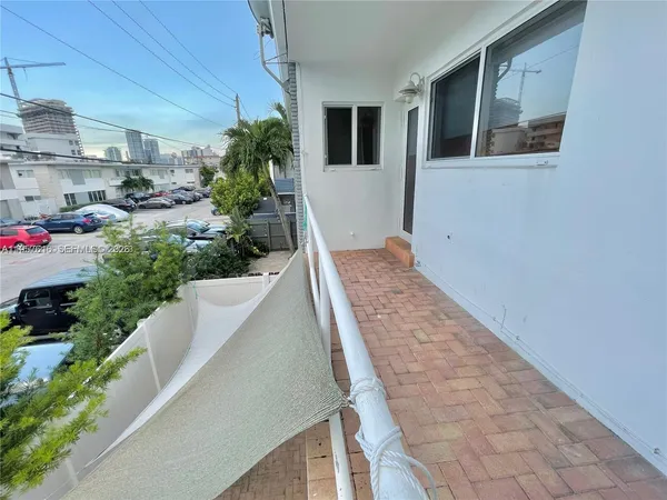 a view of a hallway with wooden floor and a potted plant