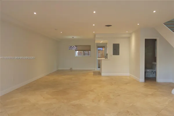 an empty room with windows and chandelier