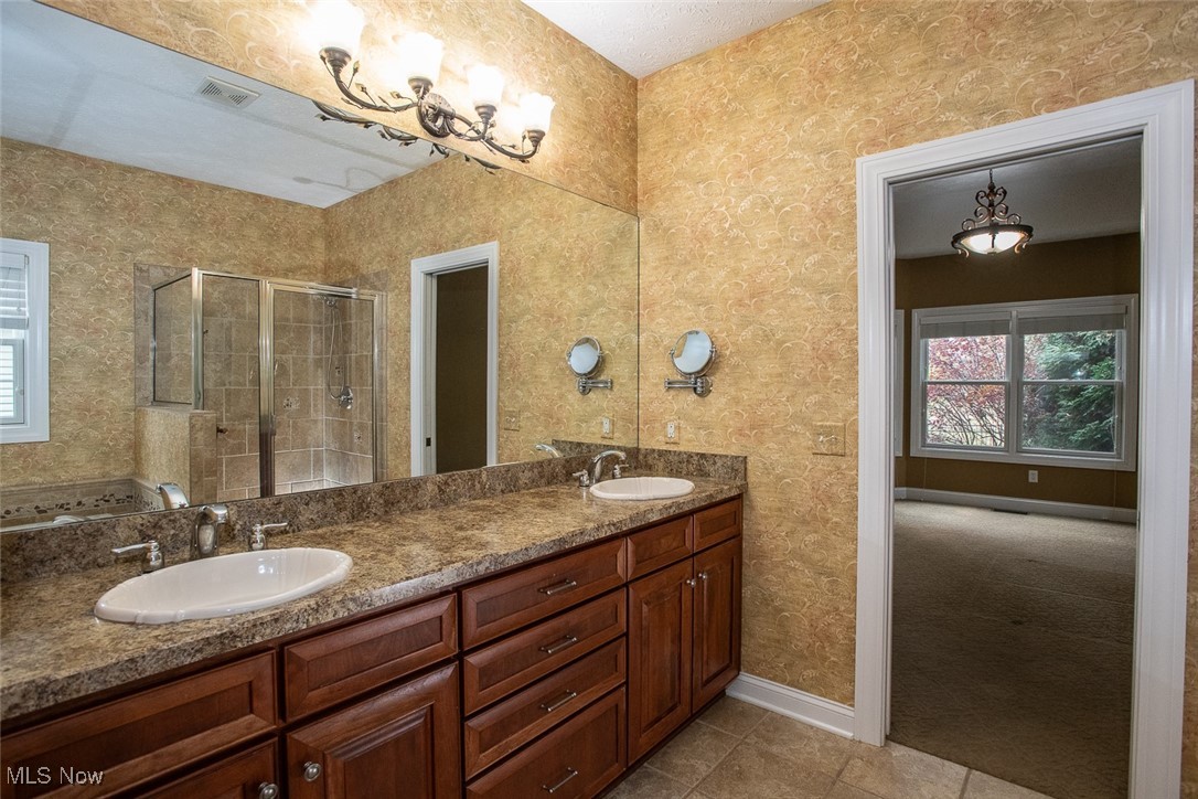 630 Rundle Street Lagrange, OH 44050 - Photo 19 of 49 Bathroom featuring wallpapered walls, a stall shower, double vanity, and light tile patterned flooring