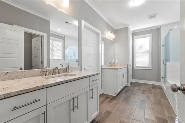 a bathroom with a granite countertop double vanity sink a mirror and a