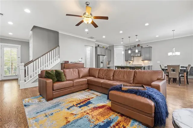 a living room with furniture kitchen view and a chandelier