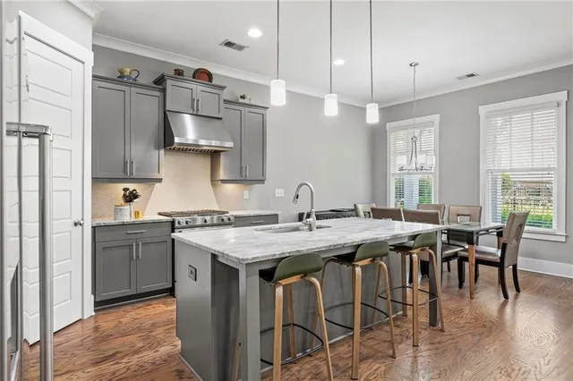 a kitchen with stainless steel appliances granite countertop a table chairs stove a sink and dishwasher