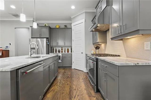 a kitchen with stainless steel appliances granite countertop a sink a stove and a refrigerator
