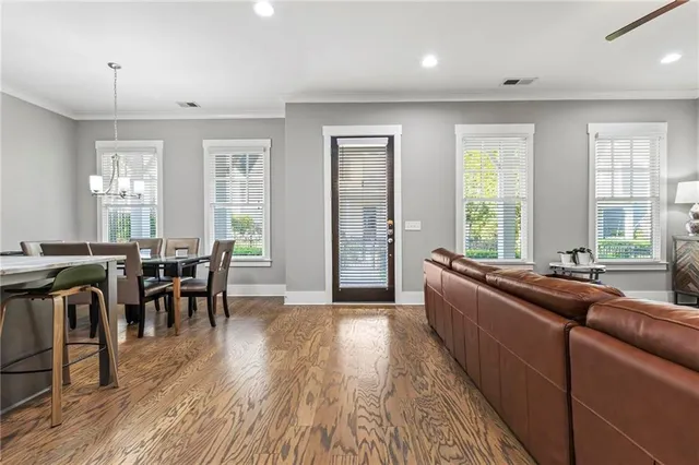 a large living room with stainless steel appliances granite countertop furniture a wooden floor and a large window