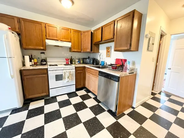 a kitchen with a checkered floor and white cabinets
