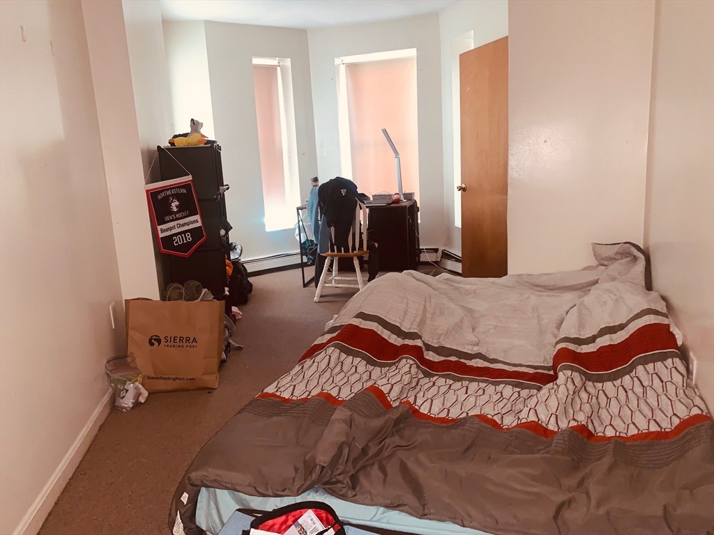 96 Hammond Street, Unit 4 Boston, MA 02120 - Photo 7 of 10 a bedroom with a bed and wooden floor