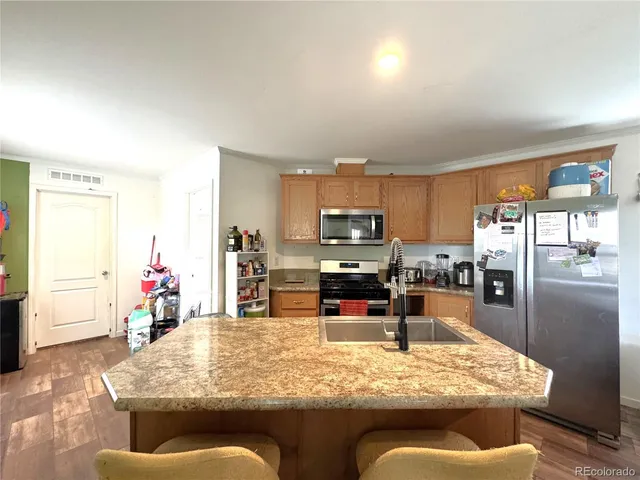 a kitchen with stainless steel appliances kitchen island granite countertop a stove and cabinets